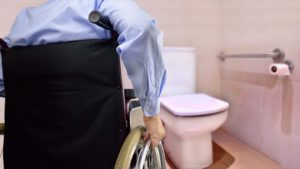 man using wheelchair to get to toilet