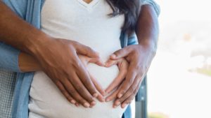 closeup of couple with hands over pregnant stomach