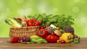 fresh vegetables and herbs over green background